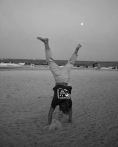 a person doing a handstand on the beach