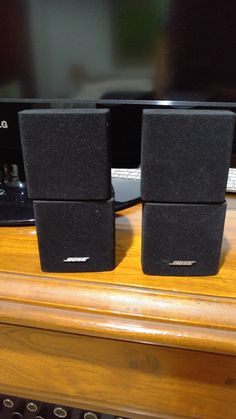 two speakers sitting on top of a wooden table