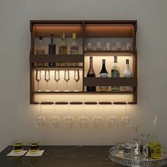 there are many bottles and glasses on the shelf above the bar counter with wine glasses