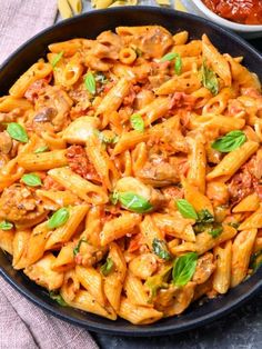 pasta with meat and sauce in a pan next to other ingredients on a table top