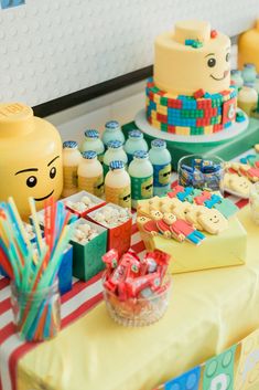 a table with lego themed cakes and candy