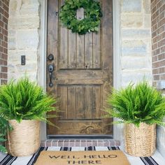 two potted plants are sitting on the front porch with a welcome mat that says, well hello there