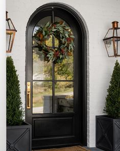 a black front door with a wreath on it