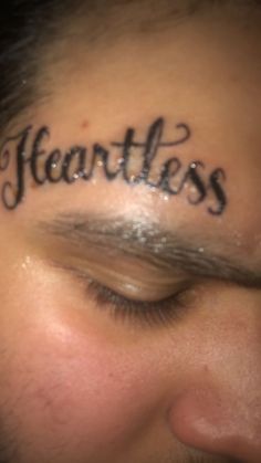 a man with the word heartless written on his forehead in cursive writing