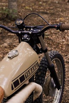 a close up of a dirt bike parked in the woods