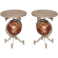 two tables with marble top and metal legs, each holding a ball on one end