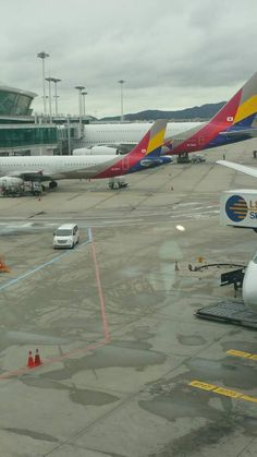 several airplanes parked at an airport terminal on the tarmac, with one plane in the foreground