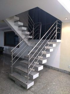 a set of stairs leading up to the second floor in a home with marble floors and white railings