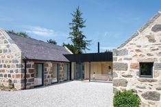 two stone buildings with windows on each side and one building has an open door in the middle