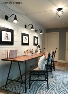 a dining room table with chairs and pictures on the wall