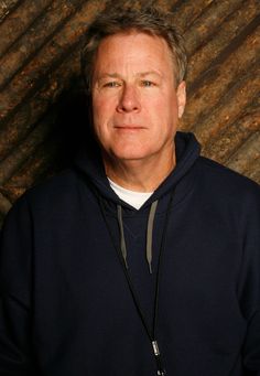 a man in a blue hoodie is posing for a photo