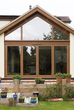 a house that has some plants in front of it and windows on the back wall