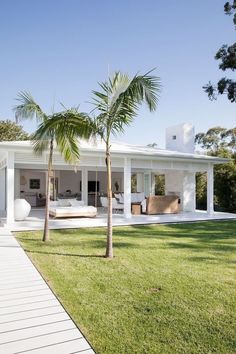 a white house with palm trees in front of it