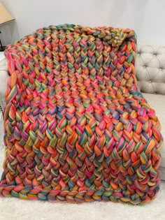 a multicolored blanket sitting on top of a white couch