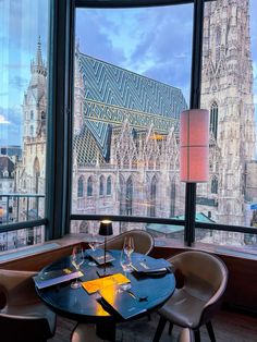 a table with place settings in front of a large window overlooking the cityscape