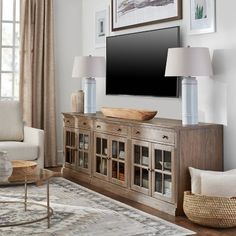 a living room filled with furniture and a flat screen tv on top of a wooden cabinet