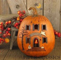 a pumpkin shaped like a house sitting on top of a wooden floor