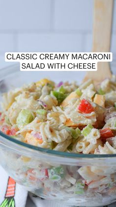 macaroni salad in a glass bowl with a wooden spoon and title overlay