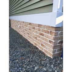 the corner of a house with a brick wall