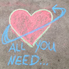 a chalk drawing of a heart and an arrow with the words all you need written on it