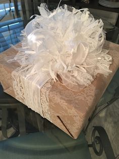 a present wrapped in lace and ribbon on top of a table