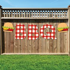 a sign that says bbq on it in front of a fence with a hamburger bun