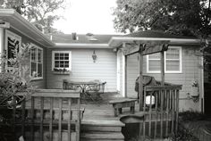 a black and white photo of a back yard with steps leading up to the house