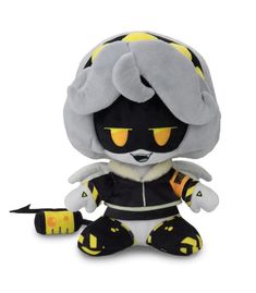 a small stuffed animal with yellow eyes and black hair sitting on a white surface next to a