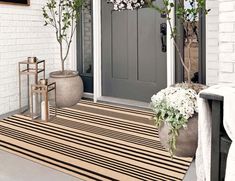 the front door is decorated with flowers and potted plants