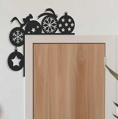 a wooden door with metal decorations on it and a potted plant next to it