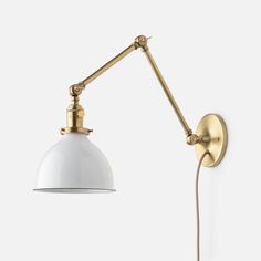 a white and gold wall light with an arm on the right side, against a white background