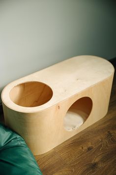 a wooden bench sitting on top of a hard wood floor next to a green bean bag