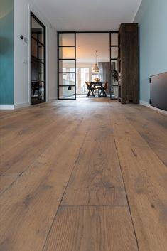 an open living room with wood floors and sliding glass doors leading to the dining area