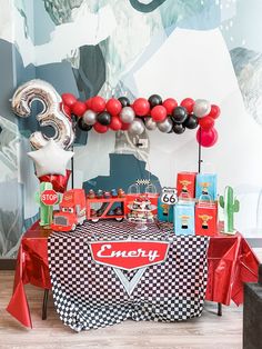 a party table with balloons and decorations for an automobile themed birthday bash or baby shower