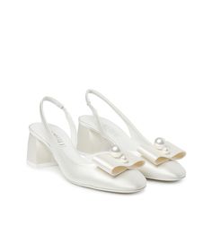 Il fiocco impreziosito da una coppia di eleganti perle aggiunge una nota romantica alle nostre slingback in pregiato raso avorio per la sposa dall'eleganza discreta. L'incantevole silhouette rivela punta arrotondata, cinturino elasticizzato posteriore, confortevole tacco midi a blocco e iconica suola in cuoio bicolore. Realizzate con la massima cura in Italia. Pearl Pumps, Kitten Heel Wedding Shoes, Ivory Shoes, Pearl Shoes, Kitten Heel Shoes, Slingback Heels, Bow Shoes, White Pumps, Elegant Shoes