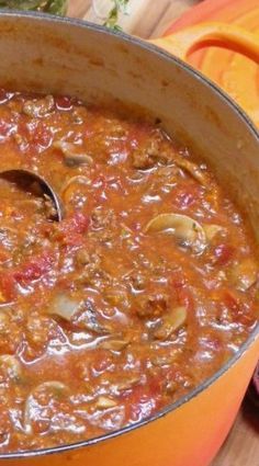 a pot filled with stew sitting on top of a wooden table