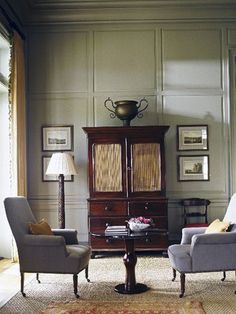 a living room with two chairs and a cabinet in it's centerpieces