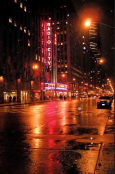 an empty city street at night with the lights on