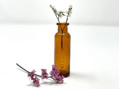 some flowers are in a brown glass bottle