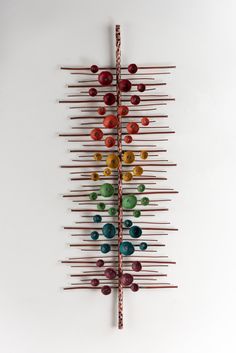 a sculpture made out of sticks and colored glass beads