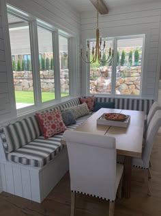 a dining room table and bench in front of windows