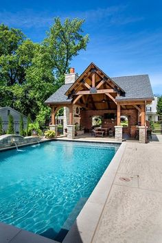 an outdoor swimming pool with a covered pavilion