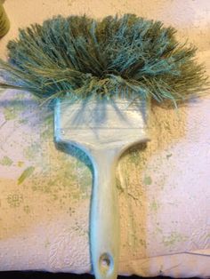 a blue brush with some green hair on it