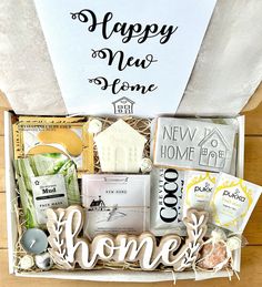 a gift box filled with happy new home cookies and other items for someone's housewarming