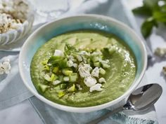 a white bowl filled with green soup and garnish