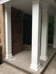 the front porch is covered with white pillars