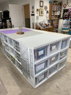 a white table with lots of bins on it in a room filled with books