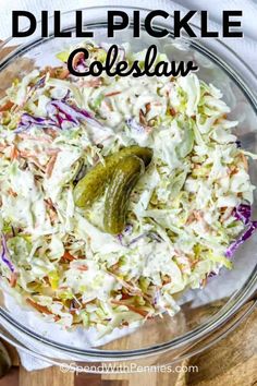 a glass bowl filled with coleslaw and pickles