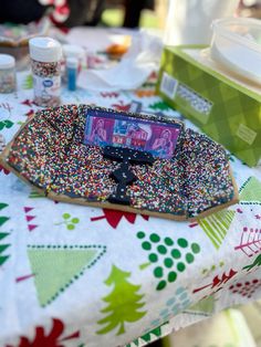 a cell phone sitting on top of a table covered in sprinkles