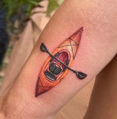 a person with a tattoo on their arm has a kayak and oars in the water